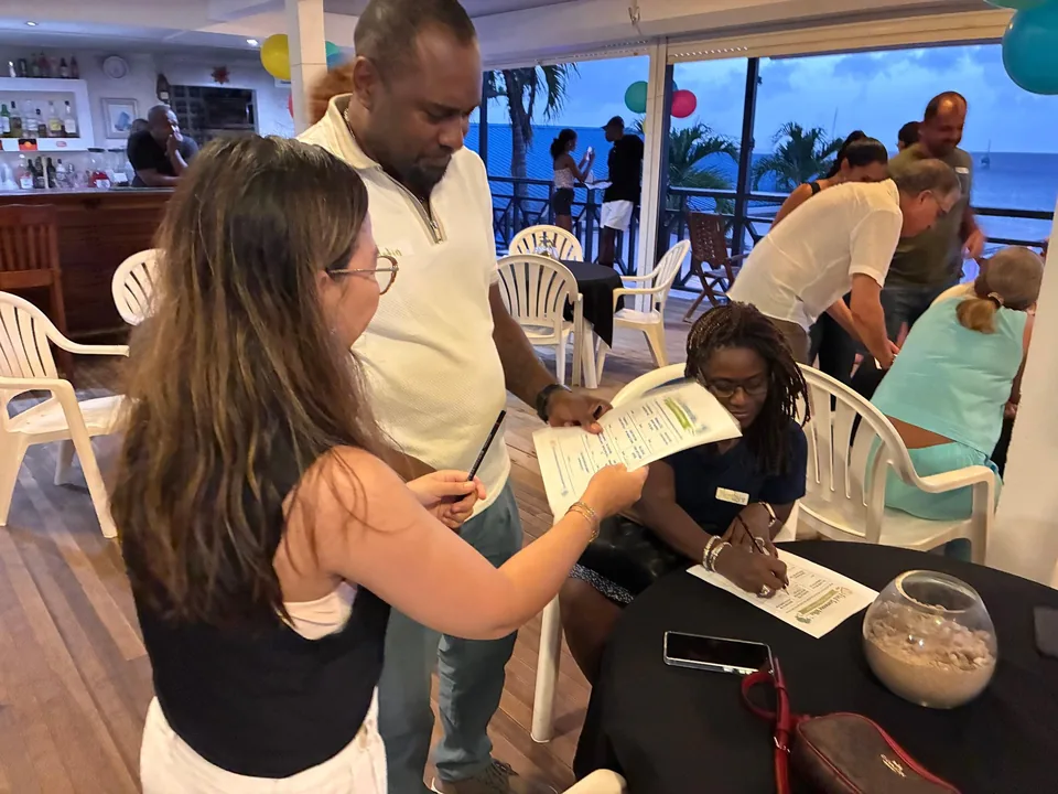 Two parents read a handout beside a seated woman writing on a form
