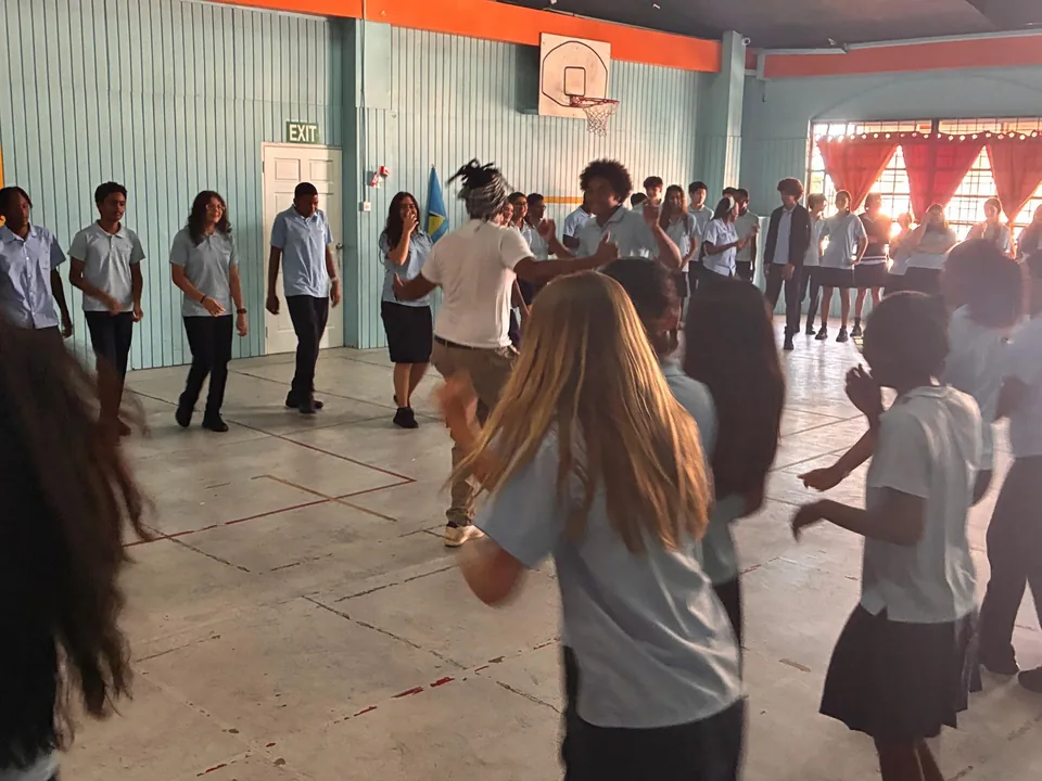 Students move and dance across the school hall during the Kalinda workshop