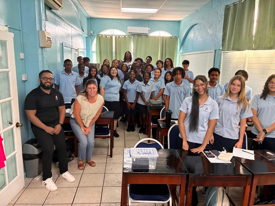 Secondary students and teachers crowd into a classroom for a group photo during the visit