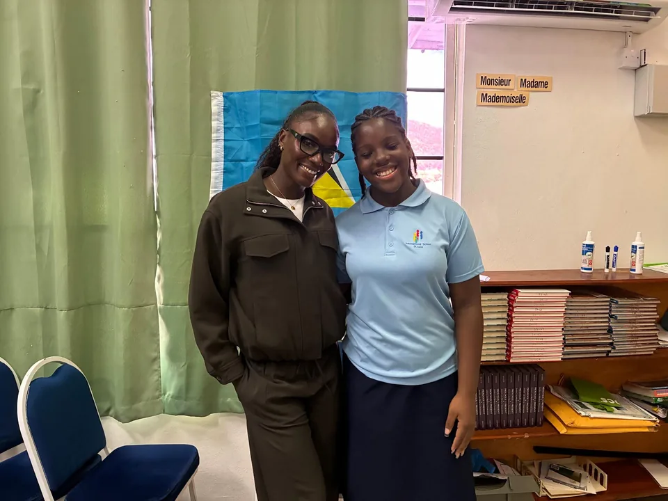 Julien Alfred smiles with a student in a classroom