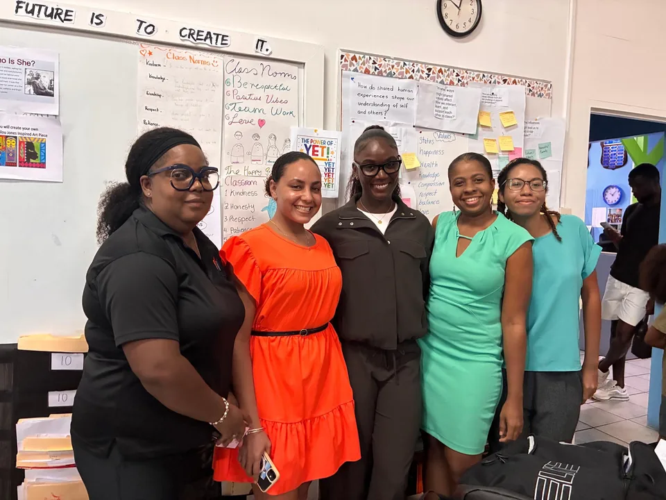Julien Alfred with four staff members in a classroom