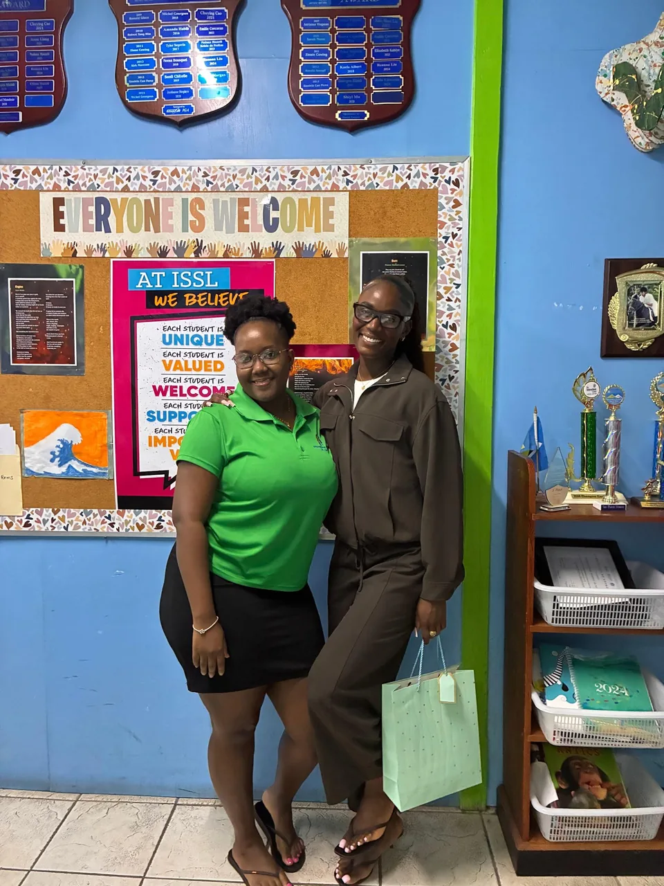 Julien Alfred with a staff member beside the 'Everyone is welcome' board